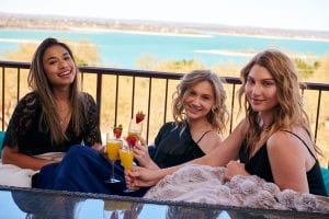 Young ladies gathered on balcony having cocktails