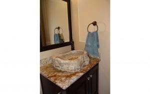 Lakehouse rental half bath with hollowed-out rock sink