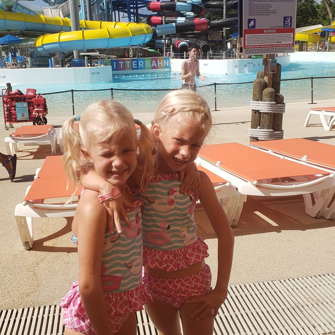 Two little girls in bathing suits hugging