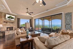 Interior rental house looking at living room out to covered deck, and a beautiful water view