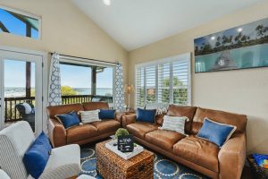 Family room with plenty of sitting, lake view, and door to covered balcony