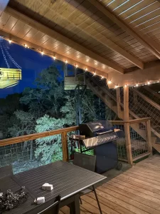 Rental vacation home lower deck lit up with grill and table