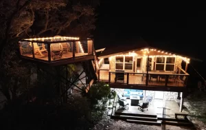 Rental vacation home lit up at night with a raised deck and lighting